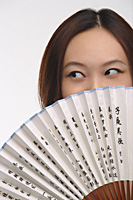 Young woman with fan looking sideways - Asia Images Group