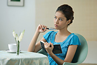Young woman sitting in restaurant, writing into journal - Asia Images Group