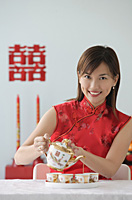 Young woman performing tea ceremony and smiling at camera - Asia Images Group
