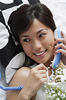 Young woman smiling while on the phone - Asia Images Group