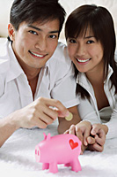 Young couple with piggy bank - Asia Images Group