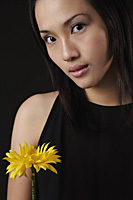 Young woman with flower looking at camera - Asia Images Group