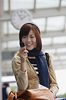 Young woman with mobile phone at the airport - Asia Images Group