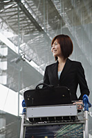 Young woman smiling into distance at the airport - Asia Images Group