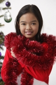 Girl with red tinsel wrap around neck shoulder - Asia Images Group