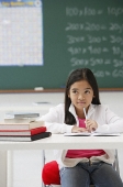 Girl sitting at school desk in classroom - Asia Images Group