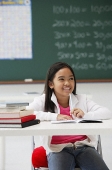 Girl smiling sitting at school desk - Asia Images Group