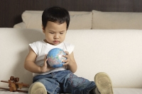 Baby boy playing with globe - Asia Images Group