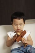 Baby boy playing with wooden toy plane - Asia Images Group