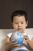 Baby boy looking at globe - Asia Images Group