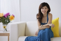 Young woman sitting on sofa - Asia Images Group
