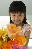 Girl with flowers smiling at camera - Asia Images Group