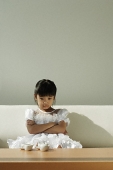Girl sitting on sofa with tea set on coffee table - Asia Images Group