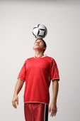 Soccer player with ball on head - Asia Images Group