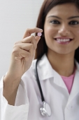 Doctor holding up a pill - Asia Images Group