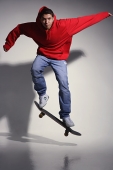 young man wearing red hooded sweatshirt on skateboard - Asia Images Group