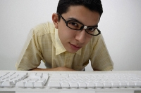 Nerd looking over keyboard - Asia Images Group