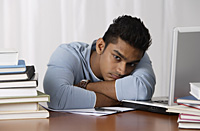 young man sitting at his desk, moody - Asia Images Group