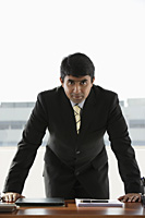 business man standing at desk - Asia Images Group