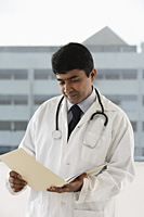 doctor looking at patient file - Asia Images Group