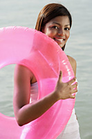woman at beach with pink tube - Asia Images Group