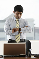 business man looking at his watch - Asia Images Group