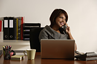 business woman talking on the phone at office desk - Asia Images Group