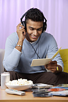 young man listening to music with headphones on - Asia Images Group
