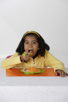 Girl eating briyani rice - Asia Images Group