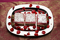 Indian pink sweets on silver tray with rose petals. - Asia Images Group