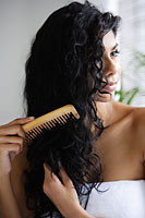 Indian woman with bare shoulders and combing her hair. - Asia Images Group