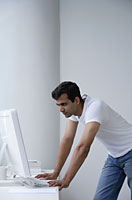 Indian man looking at computer. - Asia Images Group