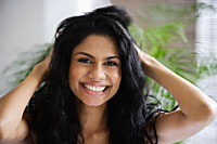 Indian woman smiling and playing with her hair - Asia Images Group