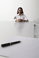 young woman sitting at end of the table being interviewed - Asia Images Group