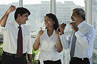 Three Indian people smiling at each other and making hand gestures - Asia Images Group