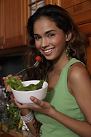 Young woman eating salad and smiling - Asia Images Group