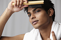 head shot of young man brushing his hair - Asia Images Group