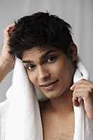 young man drying his hair with a towel - Asia Images Group
