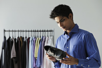 young man looking at shoes in shop - Asia Images Group