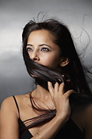 head shot of woman with hair blowing around her face - Asia Images Group