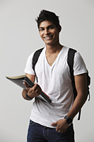 young man holding books and wearing backpack. - Asia Images Group