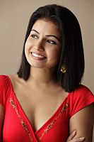 head shot of woman smiling and looking away, wearing a red dress - Asia Images Group