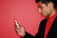 Man looking at handphone, sideview - Asia Images Group
