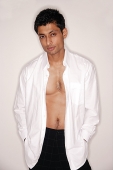 Man looking at camera, shirt fully unbuttoned - Asia Images Group