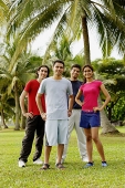 Young adults standing in park, looking at camera, hands on hips - Asia Images Group
