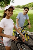 Couple on bicycles, looking at camera - Asia Images Group