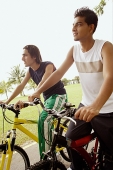 Two young men on bicycles, looking away - Asia Images Group