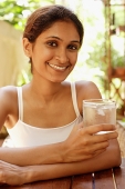 Woman holding glass of water, smiling - Asia Images Group