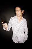 Young man looking at mobile phone - Asia Images Group