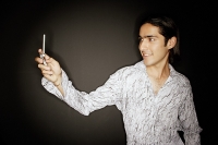 Young man looking at mobile phone, smiling - Asia Images Group